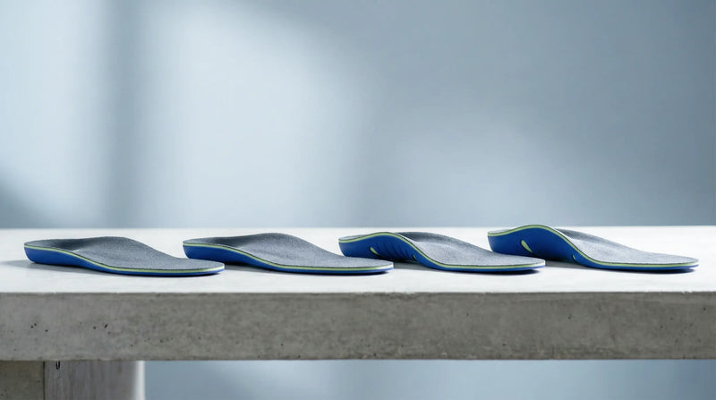 Four-stage arch support break-in timeline chart beside shoe and insole on clean desk